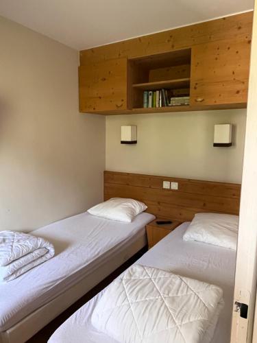 deux lits jumeaux dans une chambre aux murs en bois dans l'établissement La Plagne Appartement au pied des pistes avec vue Mont Blanc, à La Plagne Tarentaise