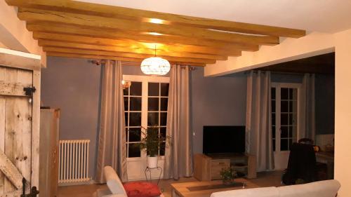 un salon avec un canapé et une télévision dans l'établissement Maison de Campagne à 2 min du zoo de Beauval, à Saint-Aignan