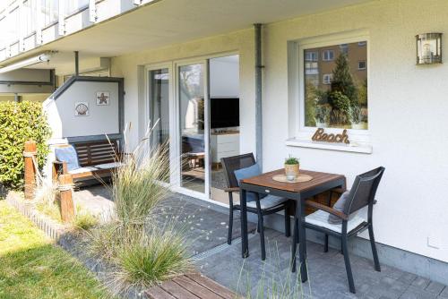 a patio with a table and chairs on a house at Meerurlaub in Laboe