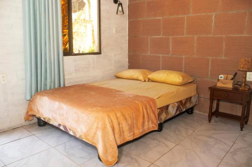 a bed in a room with a brick wall at Plaza Muyuyo in Data de Villamil