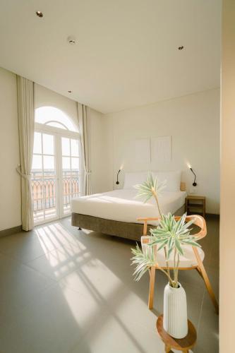 a bedroom with a bed and a table with a potted plant at HALA Home Phú Quốc in Phu Quoc