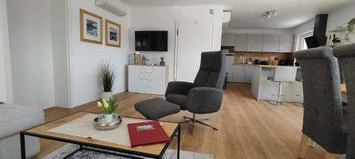 a living room with a couch and chairs and a table at Diemelsee Chalet - romantisches Ferienhaus im Sauerland Nähe Willingen Winterberg mit Seeblick in Diemelsee