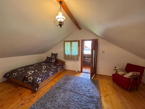 a attic bedroom with a bed and a rug at Cabana Livada Merilor in Băile Govora