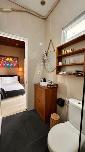 a bathroom with a bed and a toilet and a sink at iVilla in Jimbaran