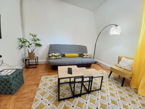 un salon avec un canapé bleu et une table dans l'établissement Superb 80 m Duplex in Mulhouse Ideal Location, à Mulhouse