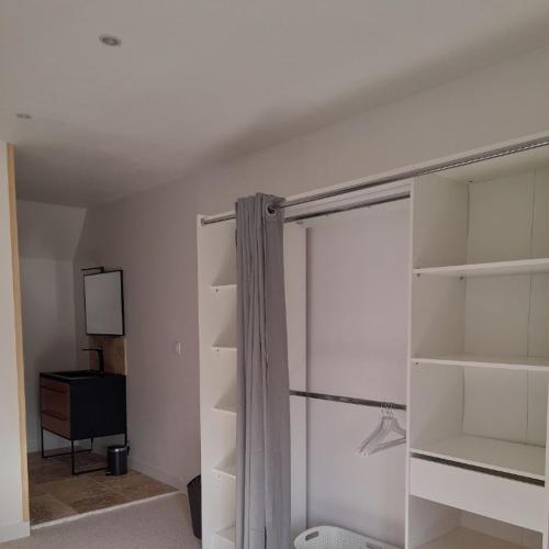 Cette chambre dispose d'étagères blanches et d'une porte coulissante en verre. dans l'établissement La Campagne de Bas, à Heugueville-sur-Sienne