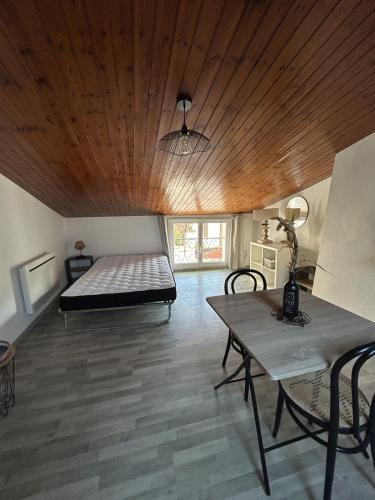 Cette grande chambre comprend un lit et une table. dans l'établissement Studio Les Sables d'Olonnes Hypercentre, à Les Sables-dʼOlonne