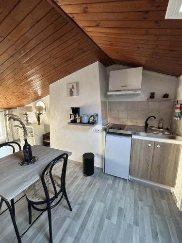 une cuisine avec une table, un évier et une cuisinière dans l'établissement Studio Les Sables d'Olonnes Hypercentre, à Les Sables-dʼOlonne