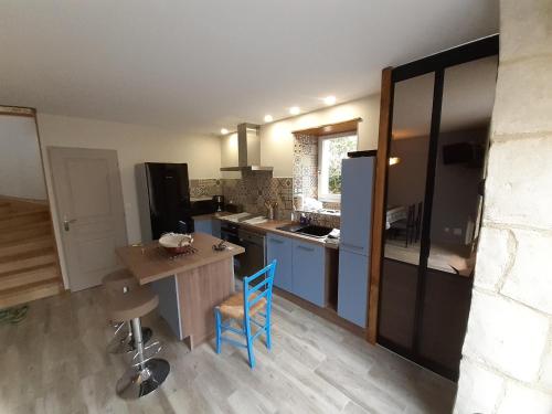 une cuisine avec une table et une chaise bleue dans l'établissement La grange à Tabac, à Goujounac