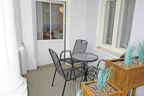 a porch with chairs and a table and some plants at Appartementhaus Sellin in Ostseebad Sellin