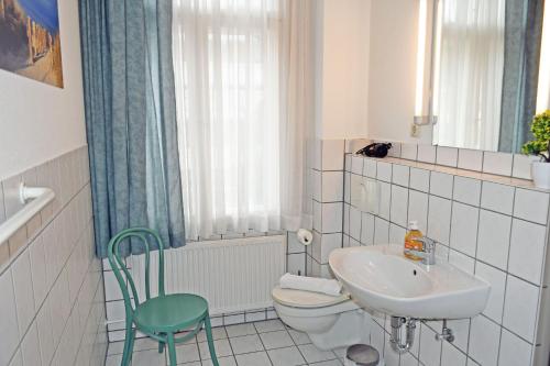 a white bathroom with a sink and a toilet at Appartementhaus Sellin in Ostseebad Sellin