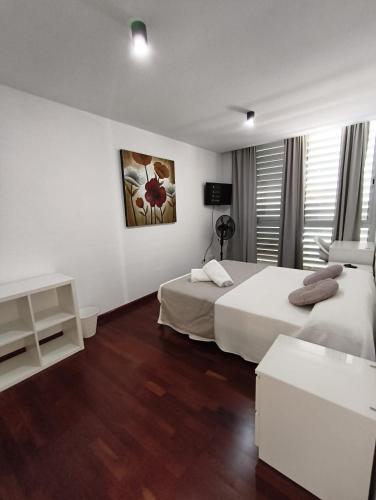 a hotel room with two beds and a television at La terraza de la Jaca in Arico