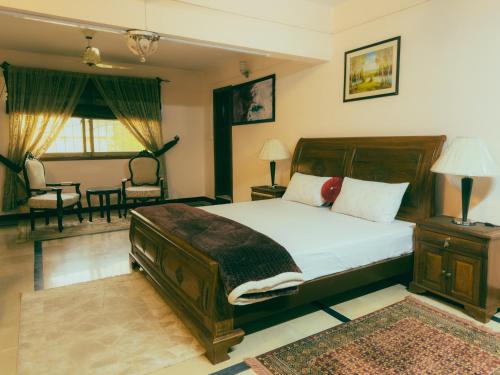 a bedroom with a large bed and a living room at Sapphire Lodges in Muzaffarabad