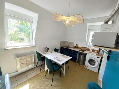 une cuisine avec une table et une machine à laver dans l'établissement Superb 80 m Duplex in Mulhouse Ideal Location, à Mulhouse