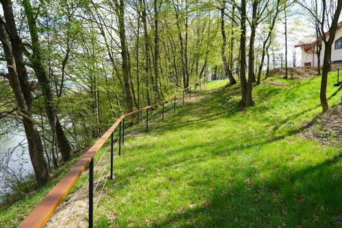 a path in the grass next to a river with trees at Apartamenty pod Dębami - noclegi Beskid Niski in Odrzechowa