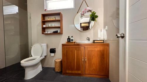 a bathroom with a toilet and a sink and a mirror at iVilla in Jimbaran