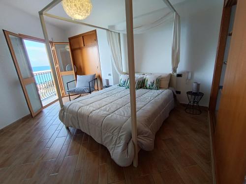 a bedroom with a canopy bed and a balcony at Finestra sul golfo in Balestrate