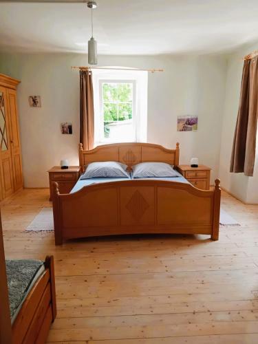 a bedroom with a wooden bed and a window at Nerezine CENTRUM apartmán pro 3 osoby in Nerezine
