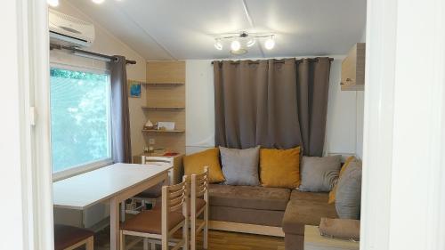 un salon avec un canapé et une table dans l'établissement MOBILE HOME tout confort à 200m de la plage, à Hyères