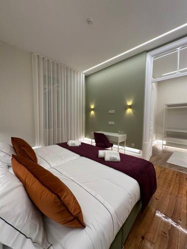 a bedroom with a large bed with a large window at Vestígios de Charme - Figueira Suits in Figueira da Foz