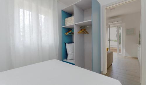 a bedroom with a white bed and a blue wall at Le Case di Chri in Mattinata