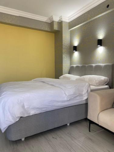 a bedroom with two beds and a chair at pasific otel in Eskiömerler