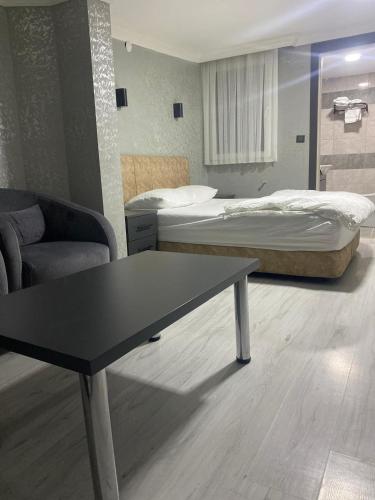 a room with two beds and a table and a couch at pasific otel in Eskiömerler