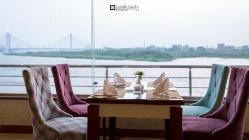 a table and chairs with a view of the water at Nile Transportation hotel in Cairo
