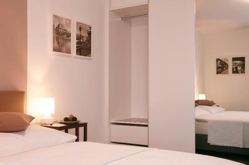 a bedroom with two beds and a mirror at Villa na Vinici in Prague