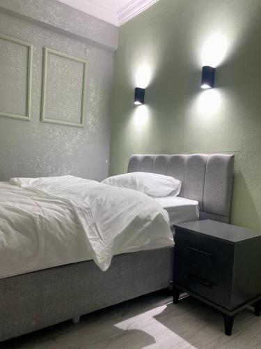 a bedroom with a bed and two lights on the wall at pasific otel in Eskiömerler