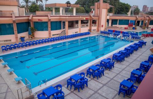 an overhead view of a swimming pool with blue chairs at Nile Transportation hotel in Cairo