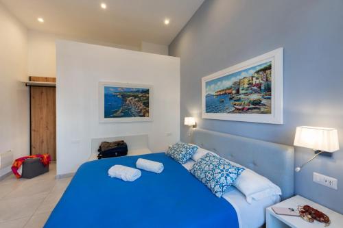 a bedroom with a blue bed and a couch at Villa Emanuel White in Sorrento