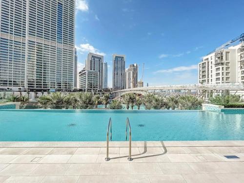 a swimming pool in a city with tall buildings at Modern 2BR Apartment - Vida Residences Creek Beach - Creek Beach Access in Dubai