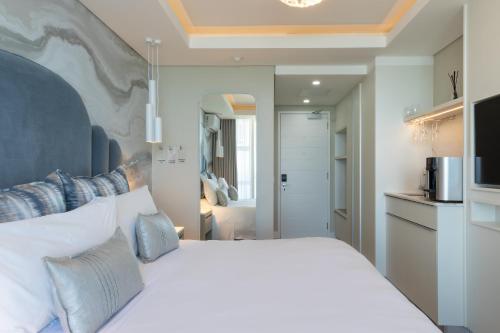 a bedroom with a white bed and a microwave at Views Boutique Hotel & Spa in Wilderness
