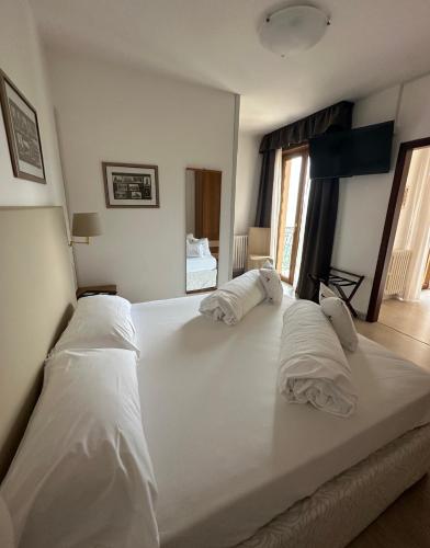a large white bed with two pillows on it at Hotel Garni Bel Sito in Tremosine Sul Garda