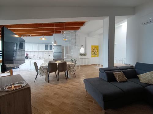 a living room with a couch and a dining room at Finestra sul golfo in Balestrate