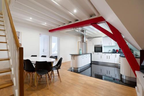 une cuisine et une salle à manger avec une table et des chaises dans l'établissement Le Spacieux - ideal for businesses & families, à Melun