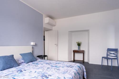a bedroom with a bed and a blue chair at Casa Mael - Spacious lakefront flat in Lierna