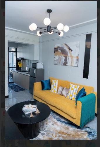 a living room with a yellow couch and a table at Cozy two bedroom apartment in Kilimani, Nairobi in Nairobi