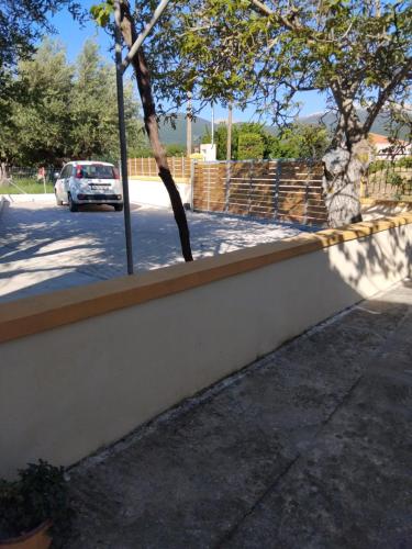 a white car parked in a parking lot behind a wall at Ira's House in Sami