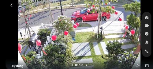 a red car is driving down a street with flowers at Phan Thiết Villa Novaworld in Bình Tú