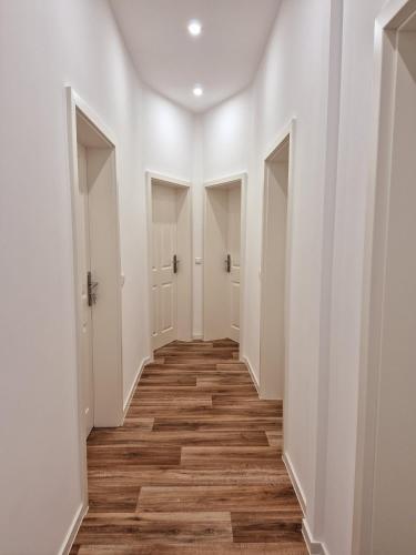 an empty hallway with white walls and wood floors at Süße Marie 17 in Karlsruhe