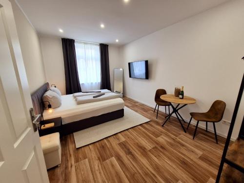 a bedroom with a bed and a table and chairs at Süße Marie 17 in Karlsruhe