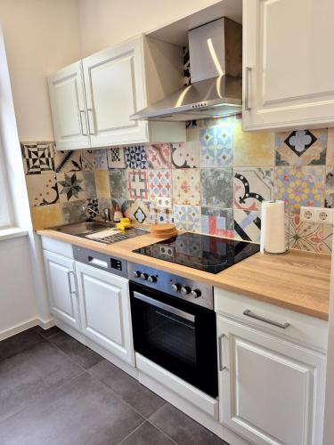 a kitchen with white cabinets and a stove top oven at Süße Marie 17 in Karlsruhe