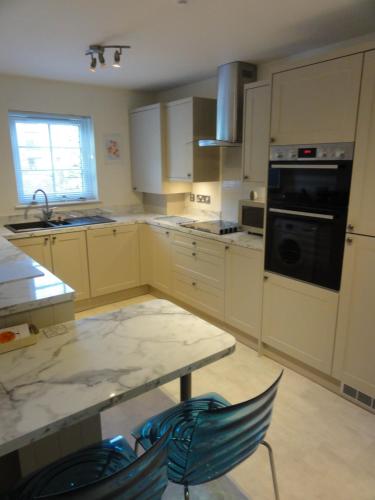 a kitchen with a table and two chairs in it at Orchard Brae in Edinburgh