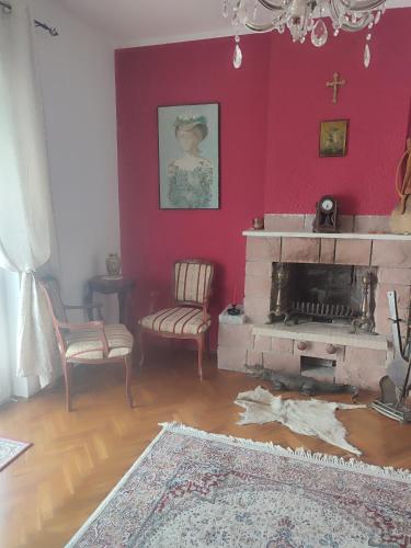 a living room with a fireplace and a red wall at Villa Terrazza in Donji Morinj