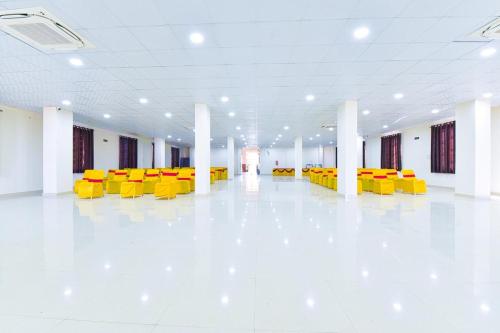 a large room with yellow chairs and a white floor at Hotel GD Palace in Mohāna