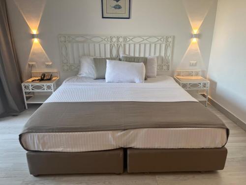 une chambre avec un grand lit avec deux tables de nuit dans l'établissement Domina Coralbay Aquamarine camera privata, à Charm el-Cheikh