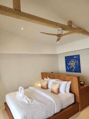 a bedroom with a bed with white sheets and a ceiling at Baan Bophut Beach Hotel Samui - SHA Extra Plus in Bophut 