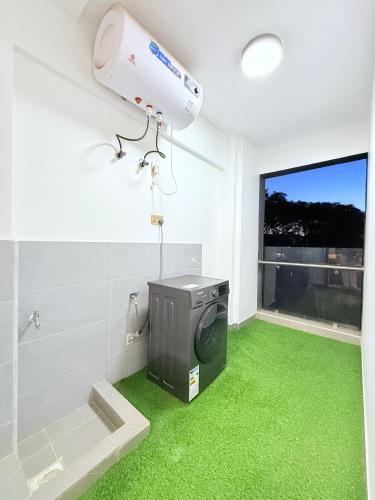 a bathroom with a washing machine and a green floor at Amari Suites in Gatunga